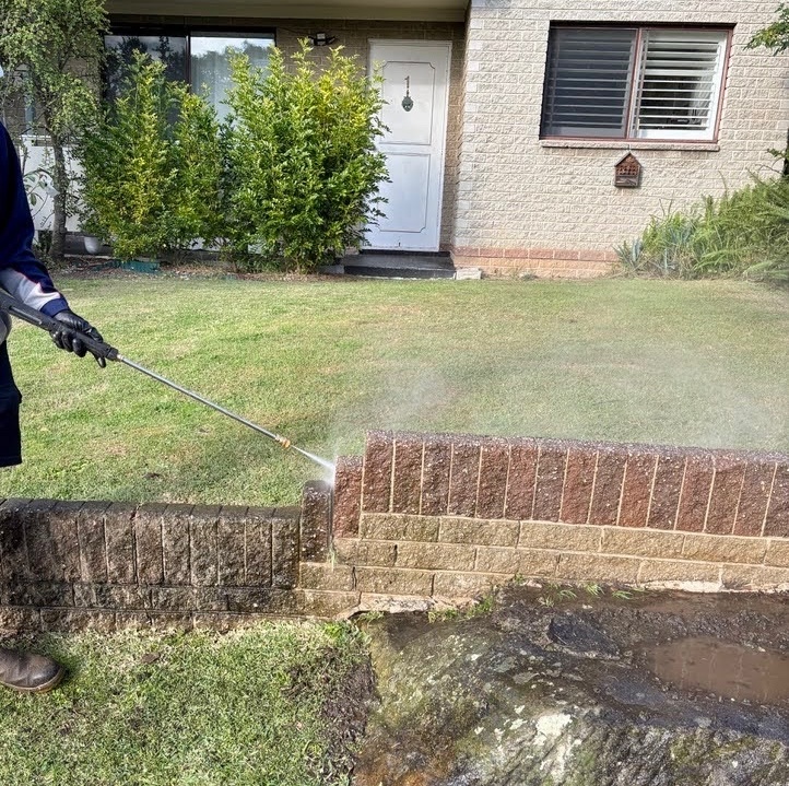 Technician pressure washing a building exterior