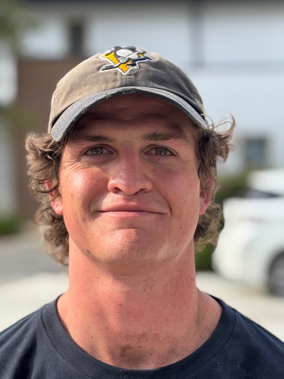 Ollie White smiling in a blue uniform